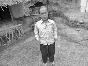 एकजना होचापुड्का व्यक्ति एउटा घर अगाडी उभिएको तस्बिर