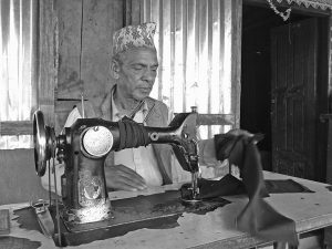 अपाङ्गता भएका पुरुष लुगा सिलाउदैं गरेको अवस्था