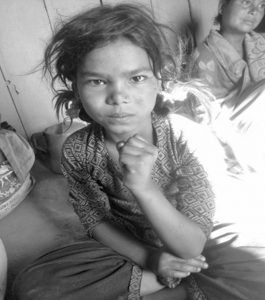 अपाङ्गता भएकी बालिका आँगनमा बसेर कुरा गर्दै