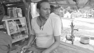 शारिरीक अपाङ्गता भएका पुरुष मिठाई पसलमा बस्दै गरेको अवस्था