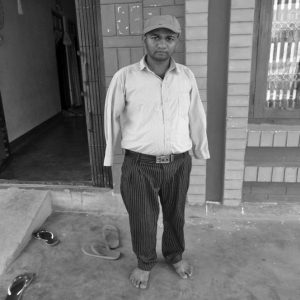 A person standing in front of building who lost his hand in the accident