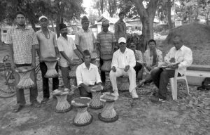 A group of person are holding bamboo tools