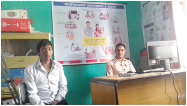 अपाङ्गता सुचना केन्द्रको कार्यालयमा दुई जना व्यक्तिहरु तस्विर खिचाउँदै गरेको