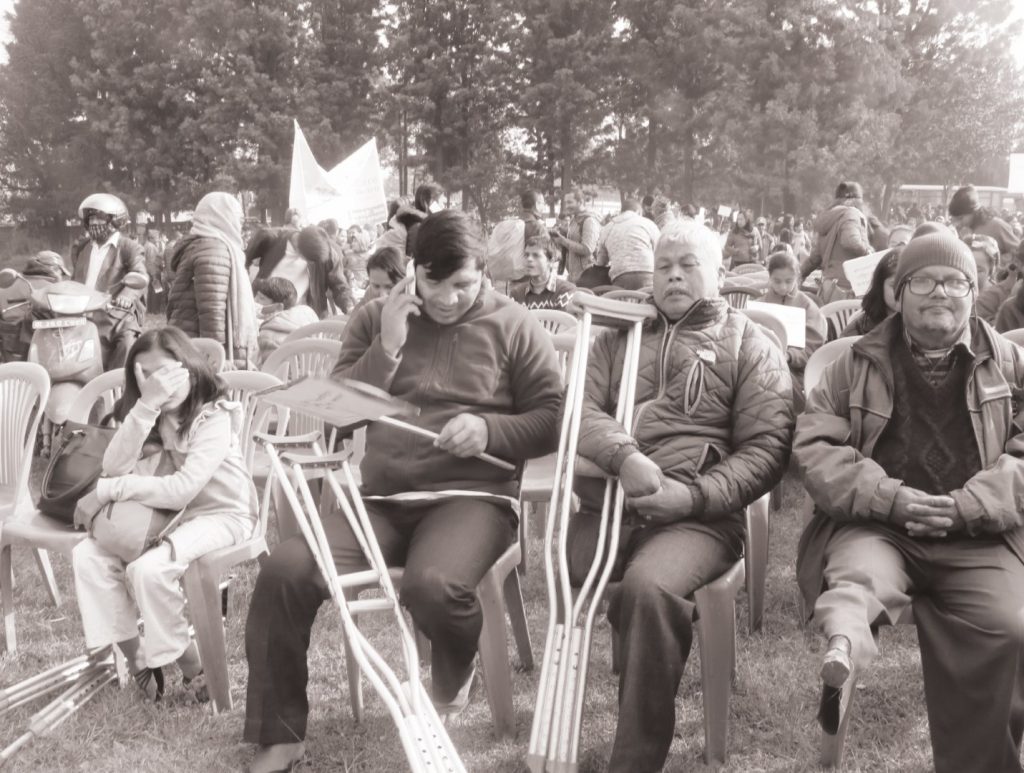 Picture of  people with various kind of disabilities sitting at the front row of a program