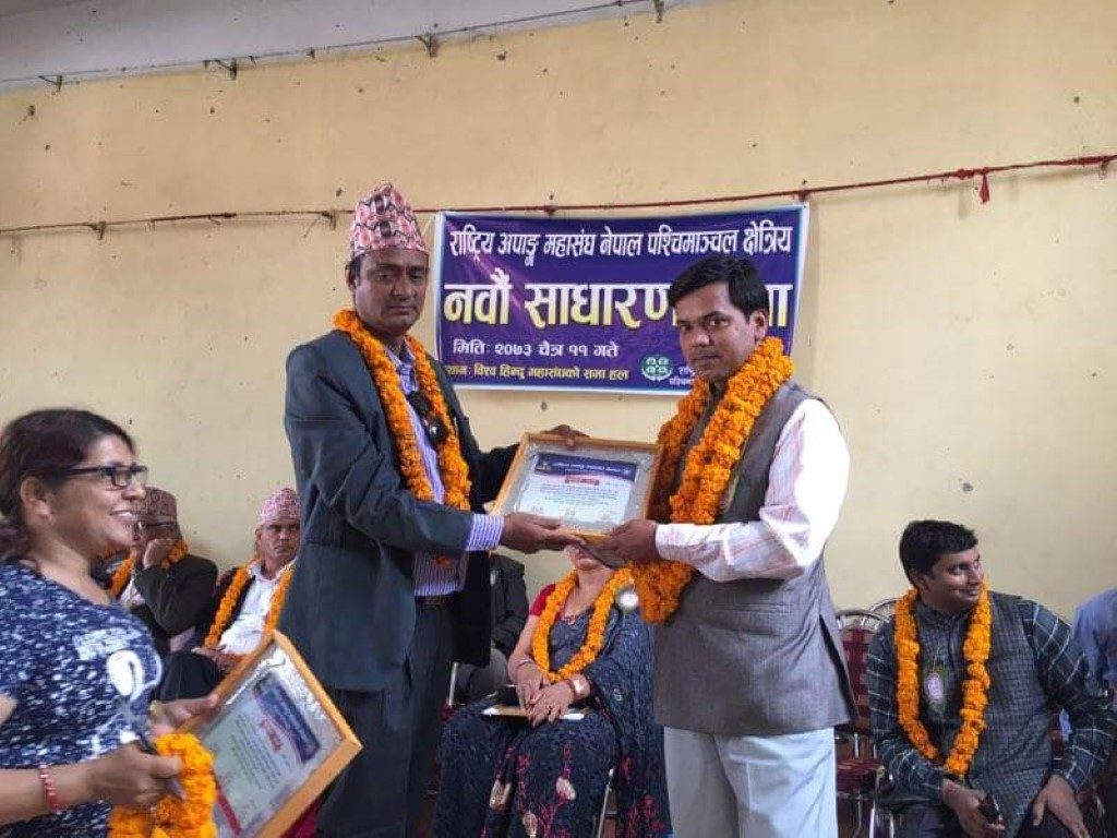 पश्चिमाञ्चल क्षेत्रीय कार्यालयको नवौं साधारण सभामा महासंघको केन्द्रिय अध्यक्ष ज्यू प्रमाण पत्र वितरण गर्दै