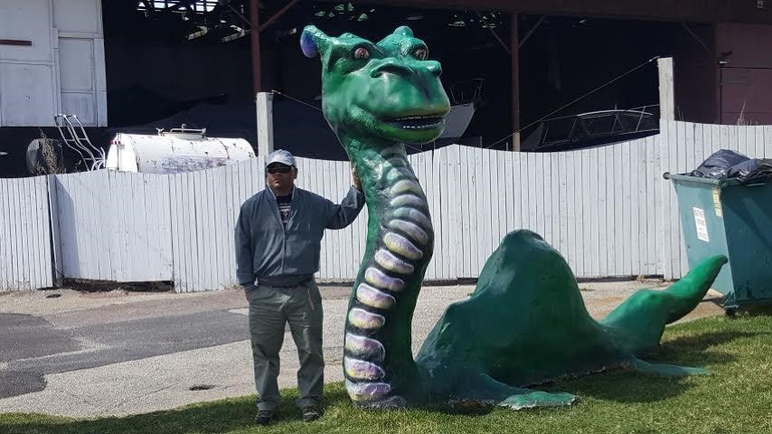 image of author infront of a statue in a park