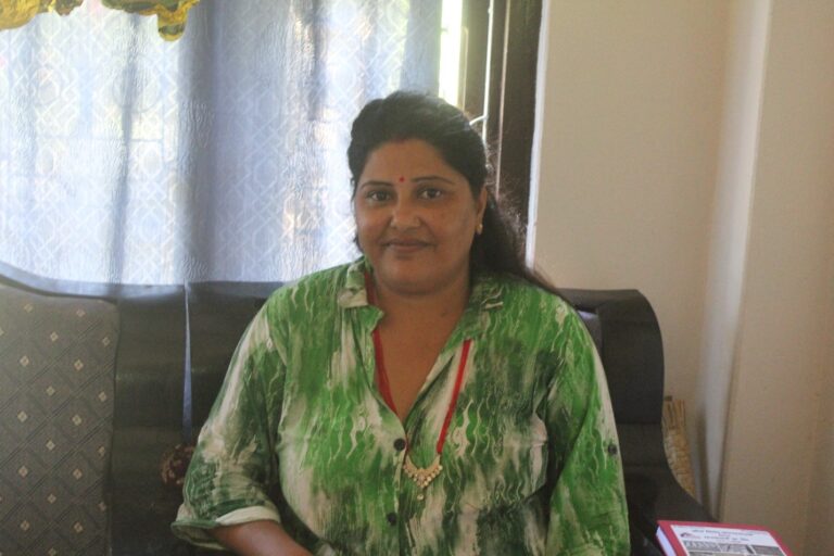 Lady in a green dress seating at sofa