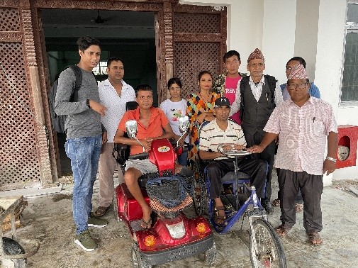 Group photo of disabled people with electric vehicle.